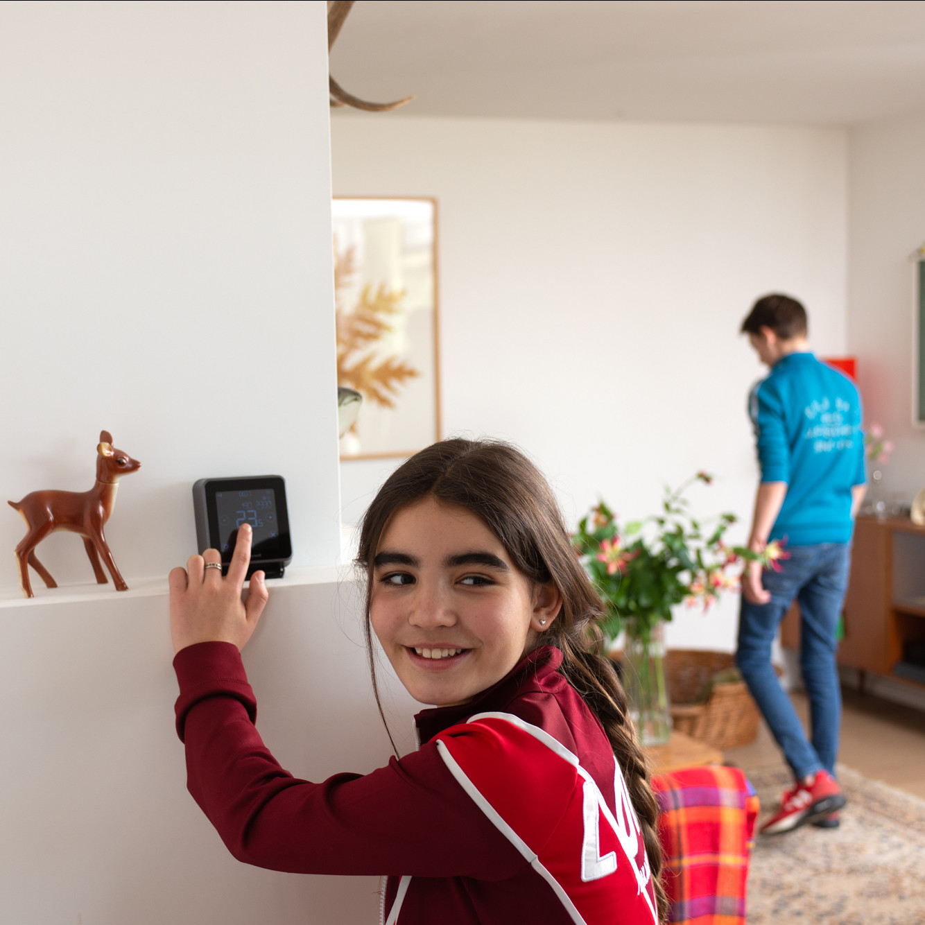 foto van een meisje dat de thermostaat in een woonkamer aanpast